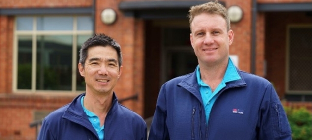 2 male clinical staff standing outside in from of the Grafton Base Hospital