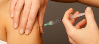 person receives vaccination injection into upper arm